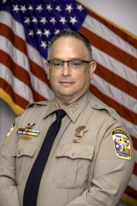 Official Portrait of Chief Charles Lanterman in front of the American flag