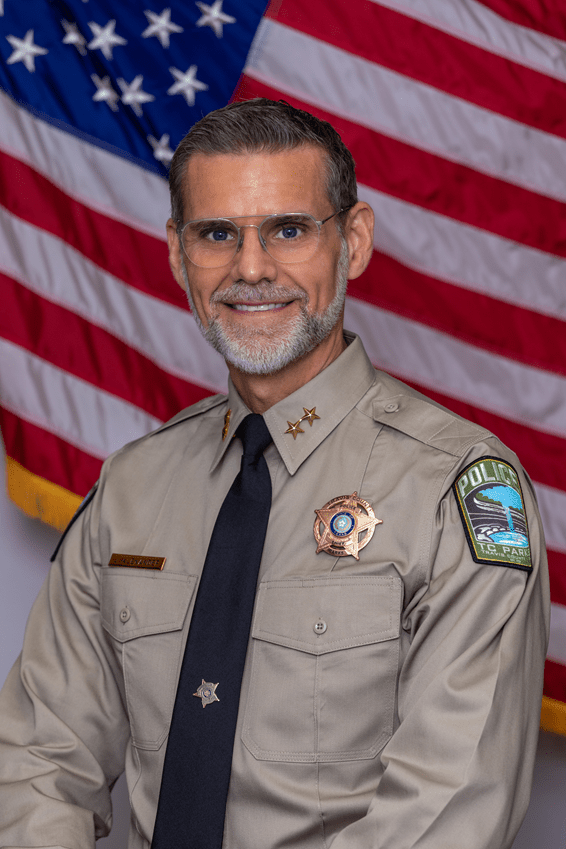 Official Portrait of Asst. Chief Jay Alexander in front of the American flag